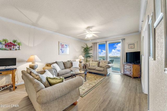 living room featuring a textured ceiling, ornamental molding, ceiling fan, and light wood-type flooring