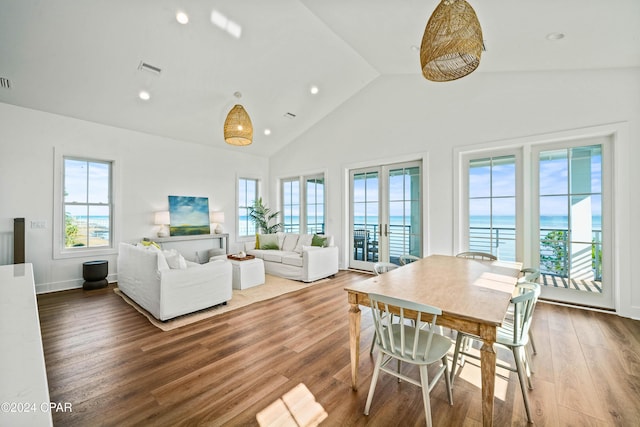 living room featuring a water view, high vaulted ceiling, and hardwood / wood-style flooring