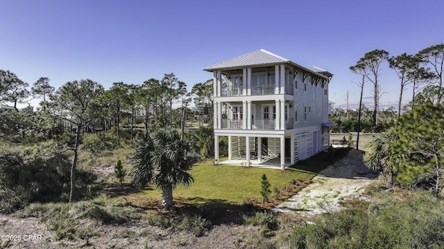 rear view of property featuring a lawn and a balcony