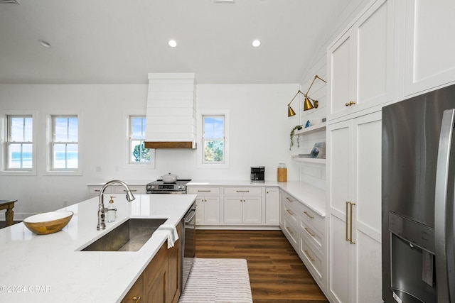 kitchen with premium range hood, light stone counters, stainless steel appliances, sink, and white cabinets