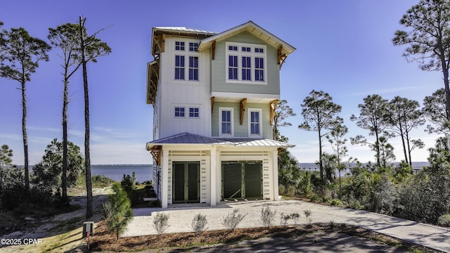 view of front of property with a garage and a water view