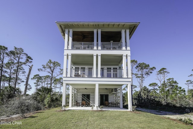 view of front of home with a front yard, a balcony, and a patio area