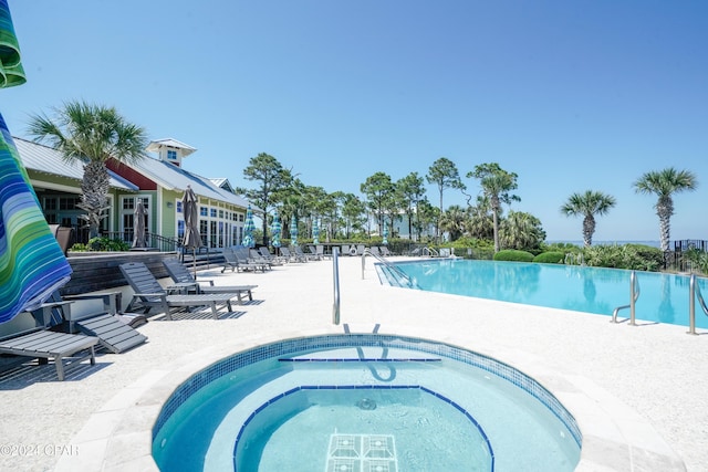 view of swimming pool with a patio and a hot tub