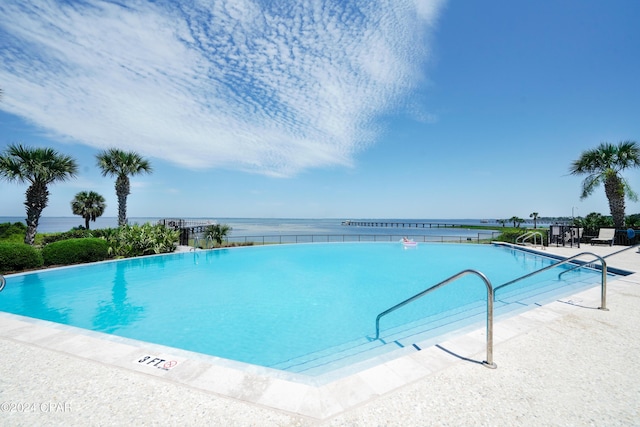 view of swimming pool with a water view and a patio area