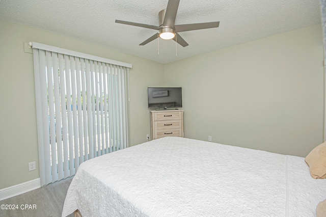 bedroom with ceiling fan and a textured ceiling