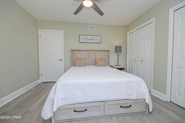 bedroom with ceiling fan, light wood-type flooring, and a closet