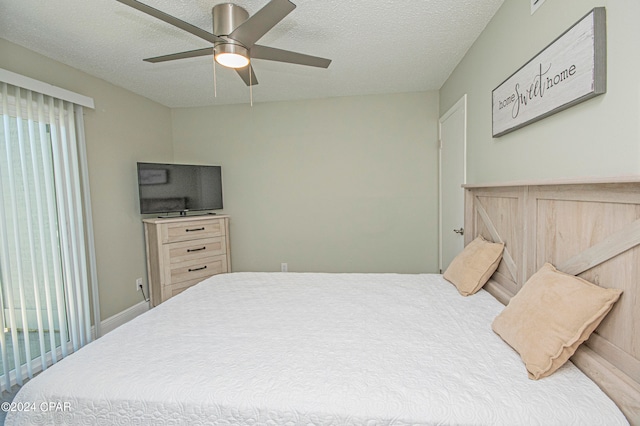 bedroom with ceiling fan and a textured ceiling