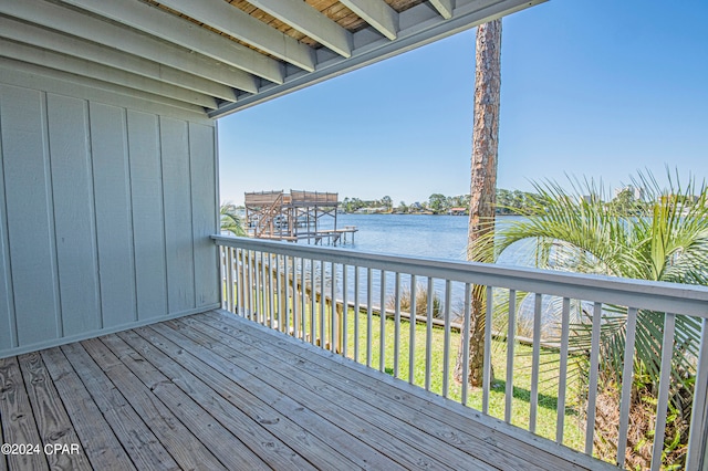 wooden deck with a water view and a yard