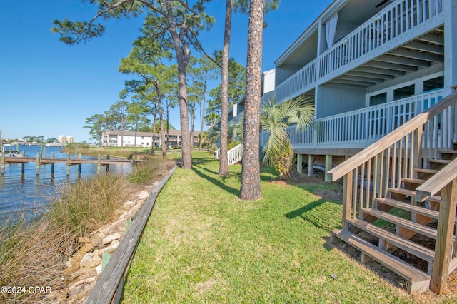 view of yard featuring a water view and a boat dock