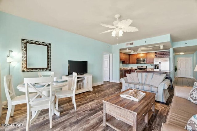 living room featuring ceiling fan and dark wood-type flooring