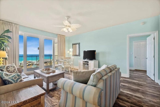 living room featuring ceiling fan, a water view, and dark hardwood / wood-style floors