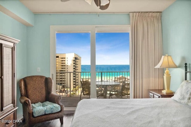 bedroom with a water view, ceiling fan, and hardwood / wood-style flooring