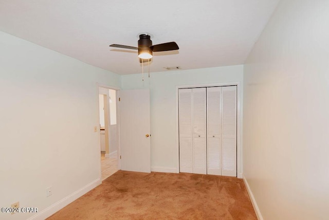 unfurnished bedroom featuring baseboards, a closet, visible vents, and light colored carpet