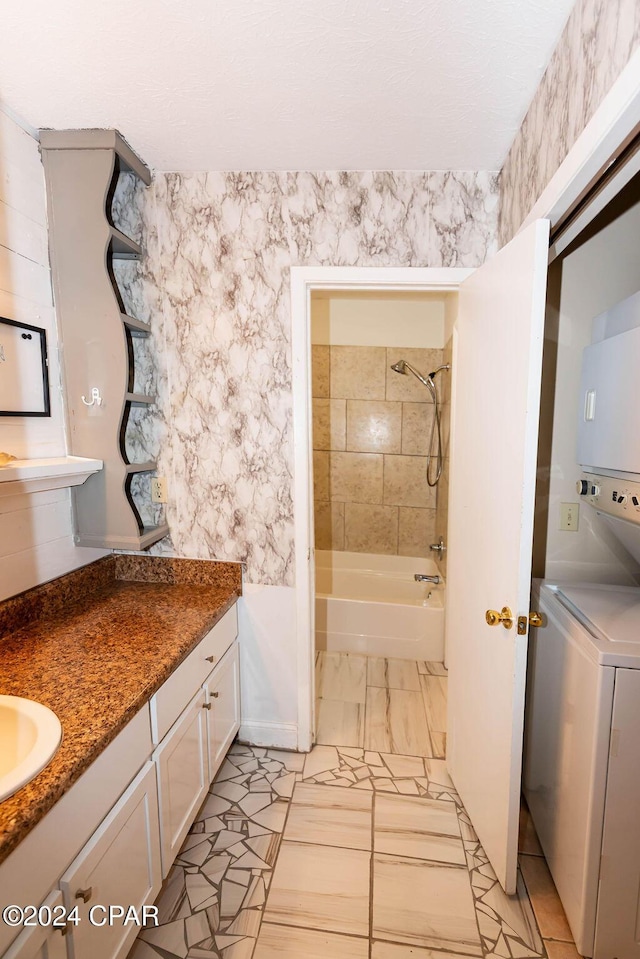 bathroom with shower / bath combination, marble finish floor, vanity, and stacked washer and clothes dryer