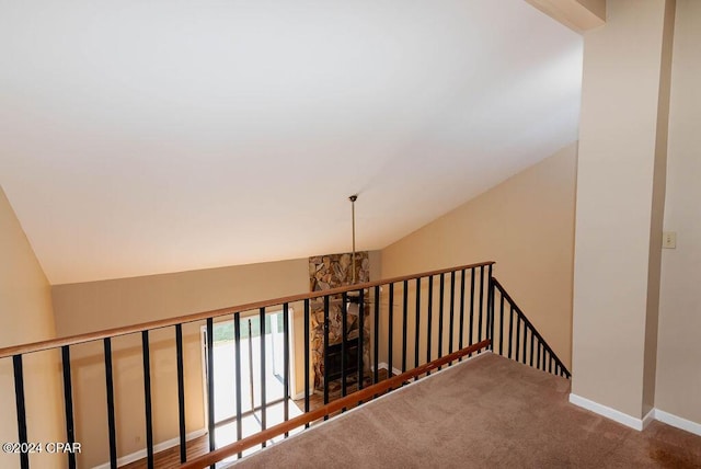 stairway with lofted ceiling, carpet flooring, and baseboards