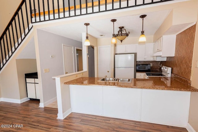 kitchen with tasteful backsplash, electric range, freestanding refrigerator, a peninsula, and baseboards