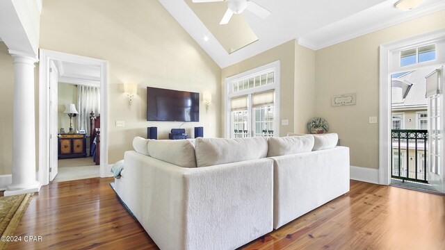 living room featuring high vaulted ceiling, ceiling fan, ornamental molding, dark hardwood / wood-style flooring, and decorative columns