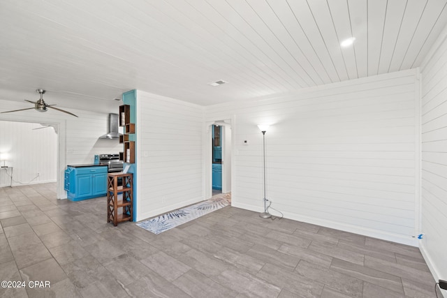 tiled empty room with wood walls and ceiling fan