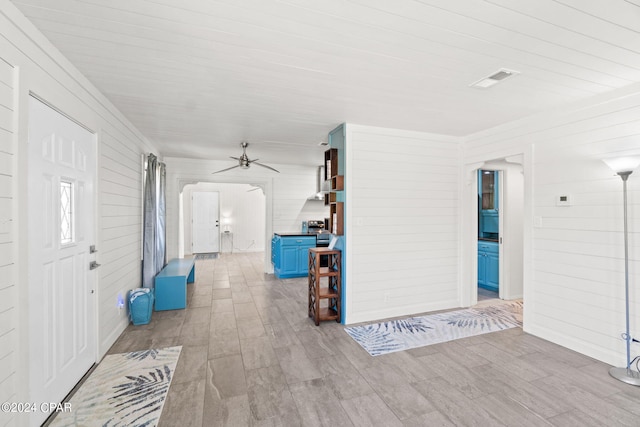 interior space featuring wood walls, ceiling fan, and hardwood / wood-style flooring