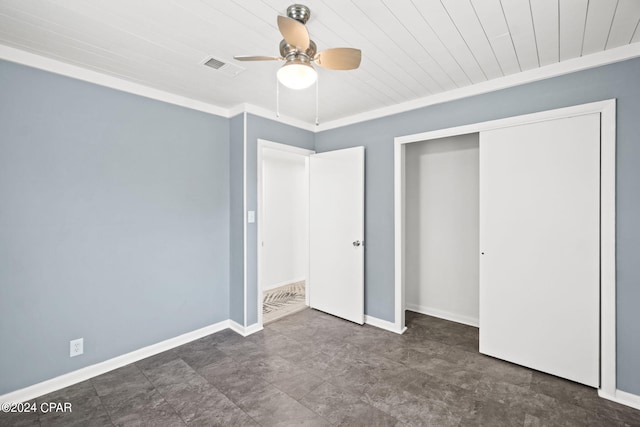 unfurnished bedroom with wood ceiling, dark tile floors, ceiling fan, and a closet