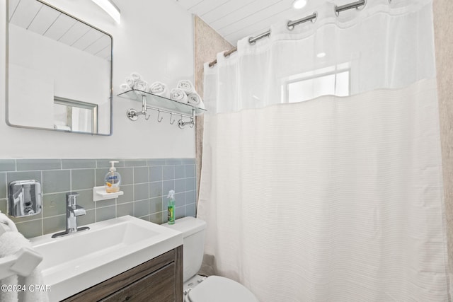 bathroom with backsplash, vanity, toilet, and tile walls