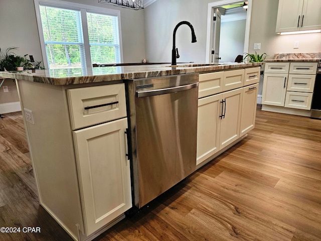 kitchen with white cabinets, light stone countertops, dishwasher, and light hardwood / wood-style flooring