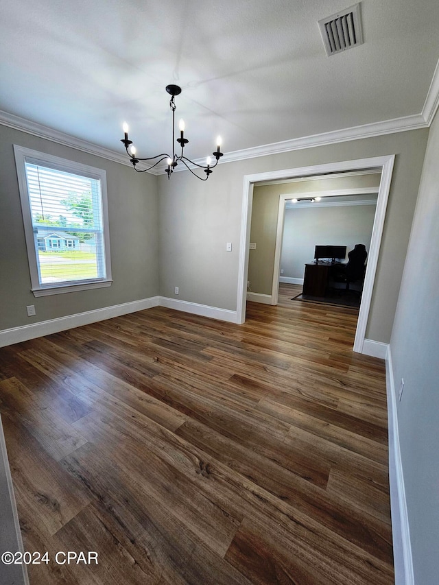 empty room featuring a chandelier, ornamental molding, and dark wood-type flooring