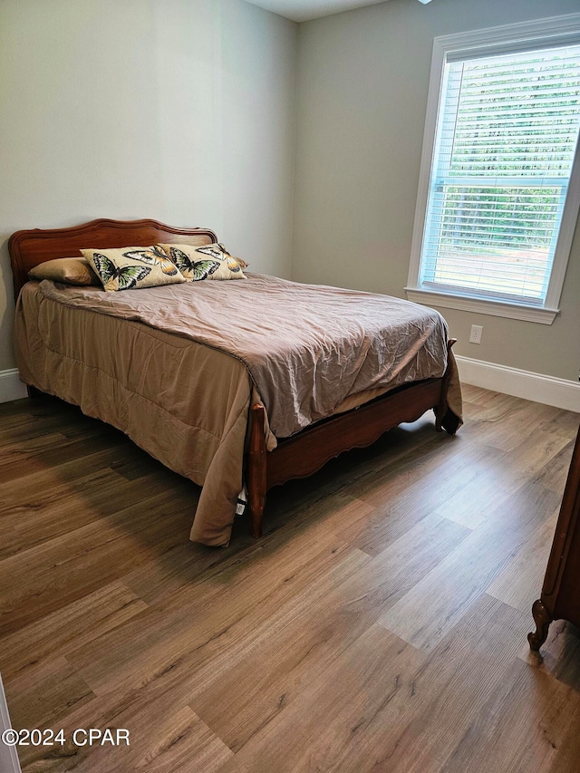 bedroom with dark wood-type flooring