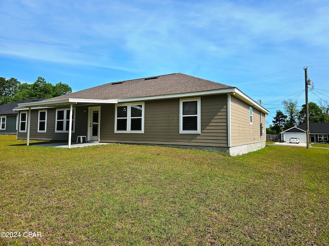 back of house featuring a lawn and a patio