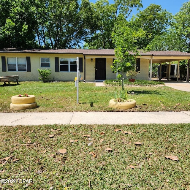 ranch-style home with a carport and a front lawn