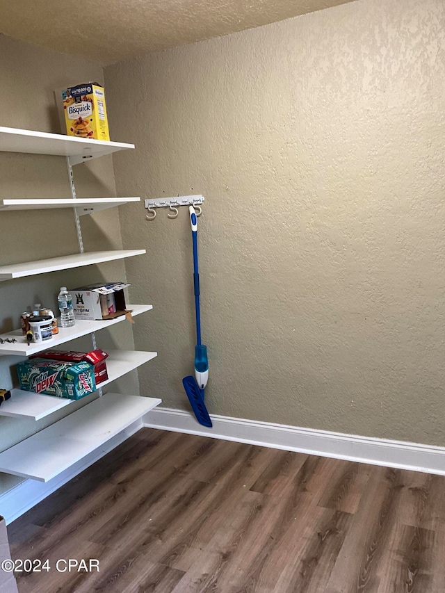 clothes washing area featuring wood-type flooring and a textured ceiling