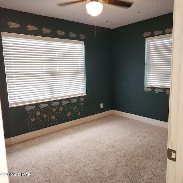 carpeted spare room with ceiling fan