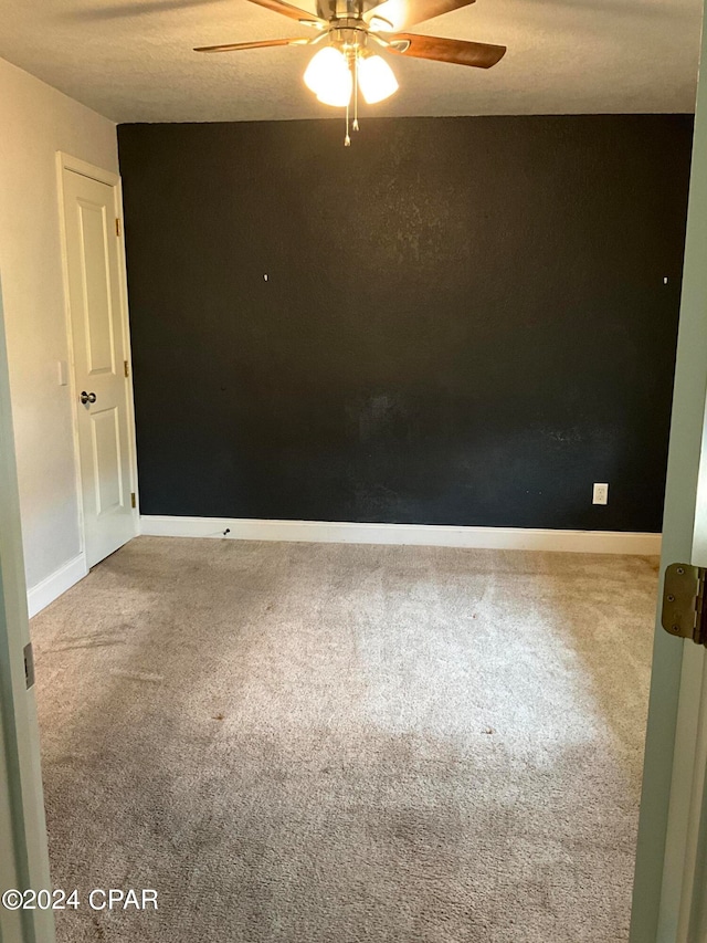 spare room featuring carpet floors and ceiling fan