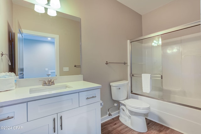 full bathroom featuring shower / bath combination with glass door, toilet, hardwood / wood-style flooring, and vanity