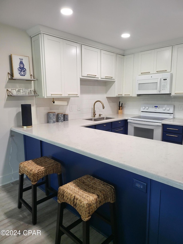 kitchen featuring white cabinetry, backsplash, dark hardwood / wood-style floors, white appliances, and sink