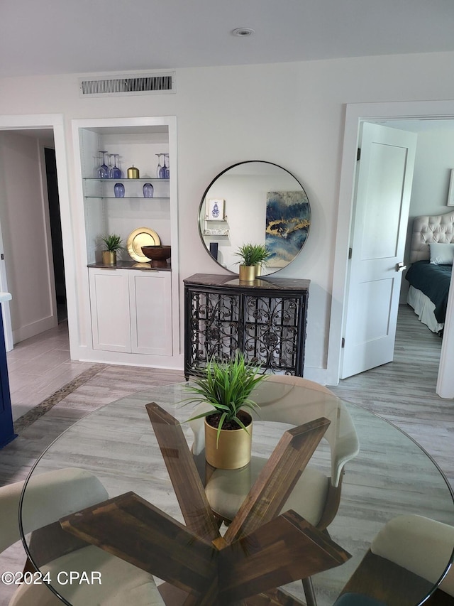 living room featuring built in shelves and light wood-type flooring