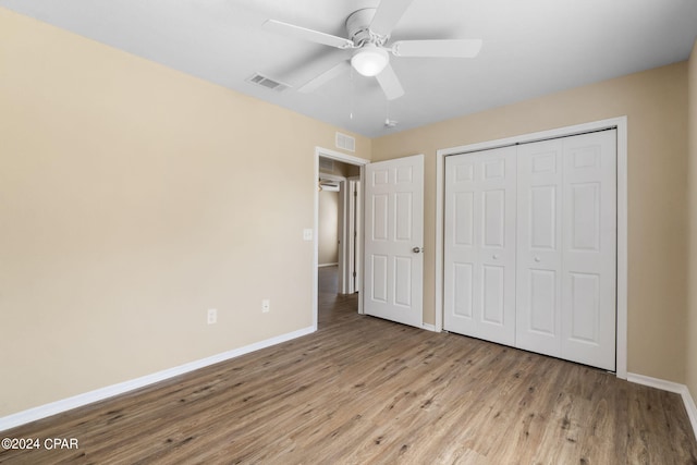 unfurnished bedroom featuring ceiling fan, light hardwood / wood-style floors, and a closet