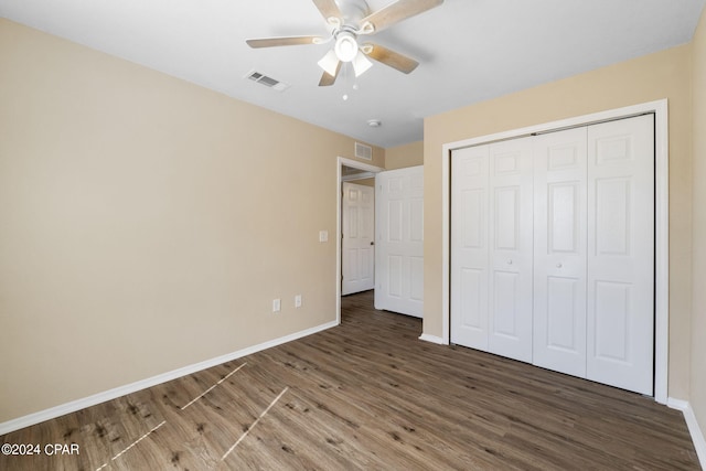 unfurnished bedroom featuring a closet, ceiling fan, and dark hardwood / wood-style flooring