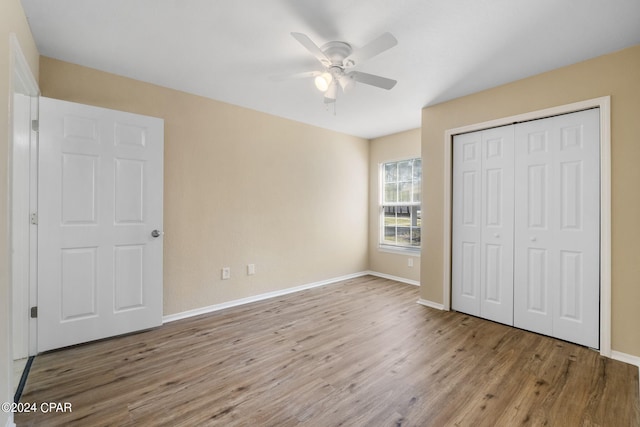 unfurnished bedroom featuring ceiling fan, light hardwood / wood-style floors, and a closet