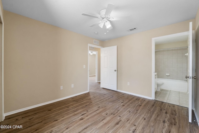 unfurnished bedroom with connected bathroom, ceiling fan, and hardwood / wood-style floors