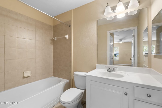 full bathroom featuring vanity, ceiling fan, toilet, and tiled shower / bath