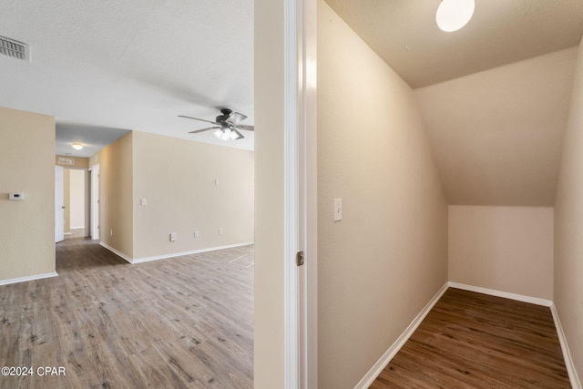 hallway with hardwood / wood-style floors and lofted ceiling