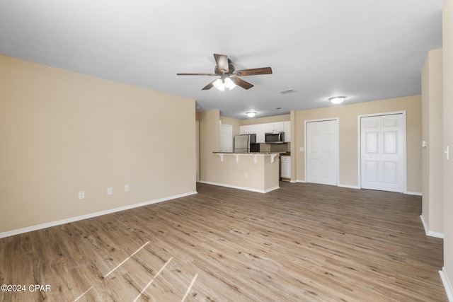 unfurnished living room featuring light hardwood / wood-style flooring and ceiling fan