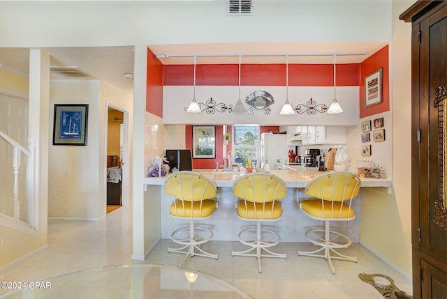 bar with light tile floors, white fridge, and pendant lighting