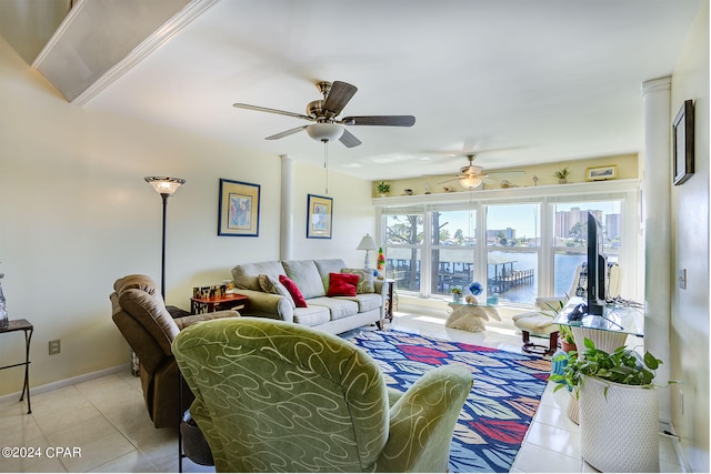 living room featuring ceiling fan, a water view, and light tile floors