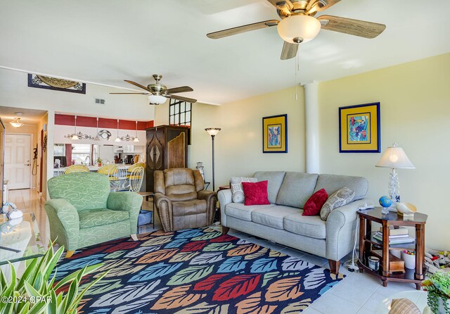 living room featuring light tile floors and ceiling fan