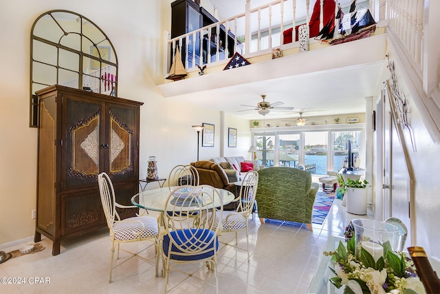 dining space featuring a water view, ceiling fan, and light tile flooring