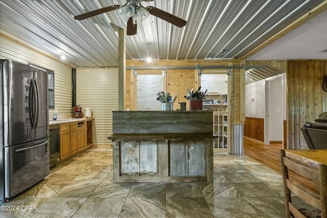 kitchen with tile flooring, ceiling fan, wooden walls, and stainless steel fridge