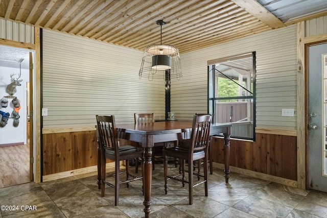 dining area with wood walls and tile flooring