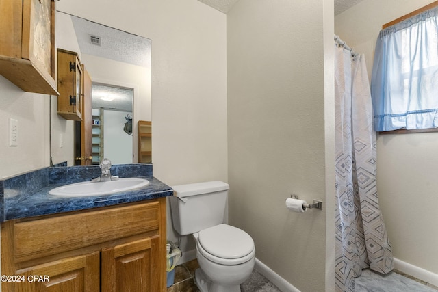 bathroom featuring tile floors, toilet, and a textured ceiling